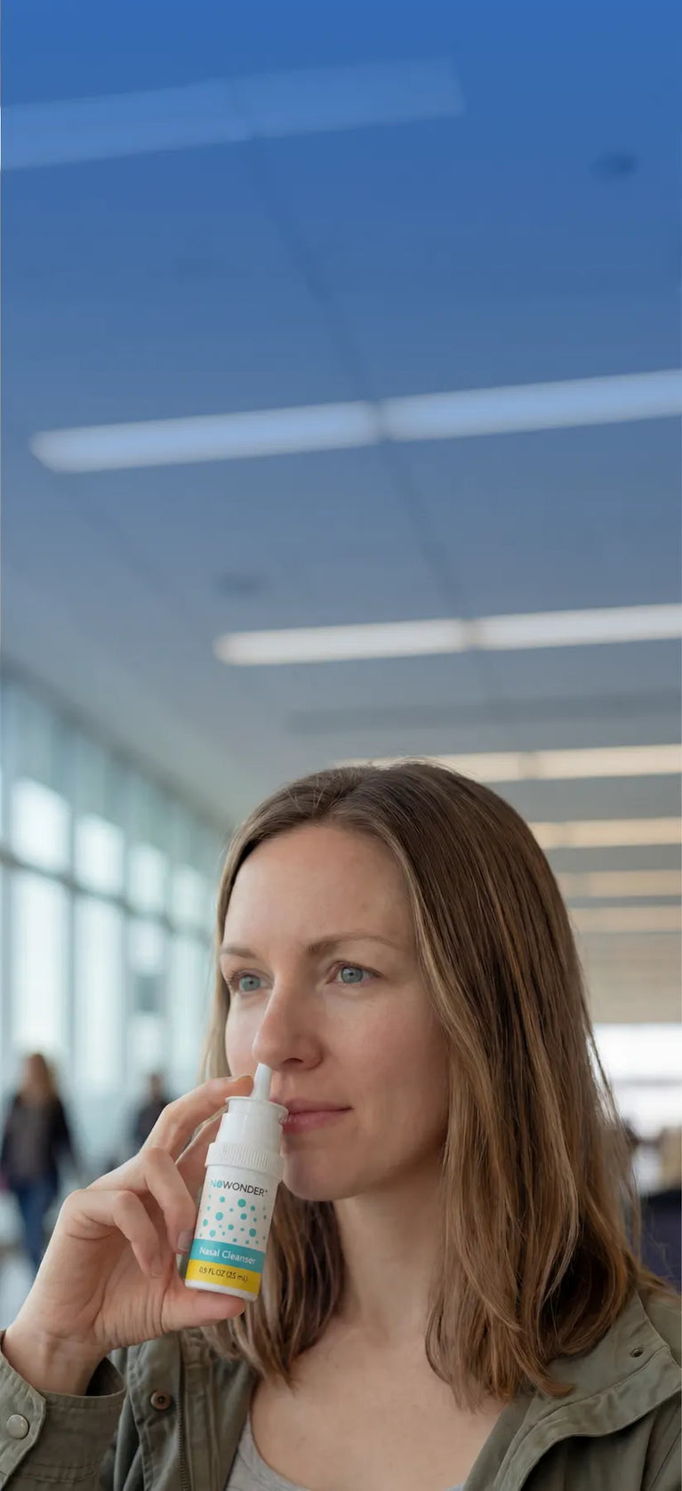 Woman using Enovid (NoWonder) nitric oxide nasal spray at an airport